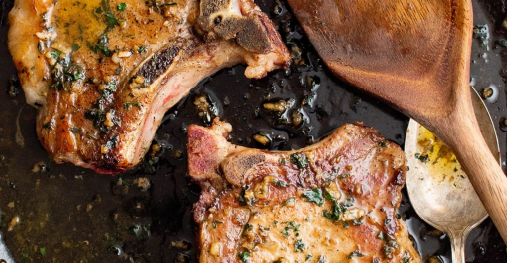 an image of pan seared pork chops on a cast iron skillet