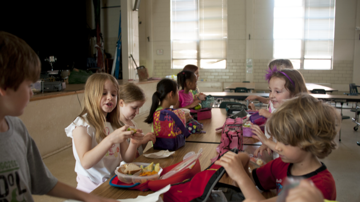 An image of children eating lunch at the school table